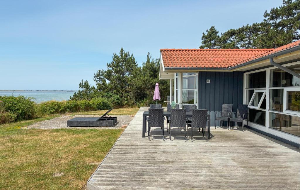 a house with chairs and a table and an umbrella at Awesome Home In Gørlev With Wifi in Gørlev