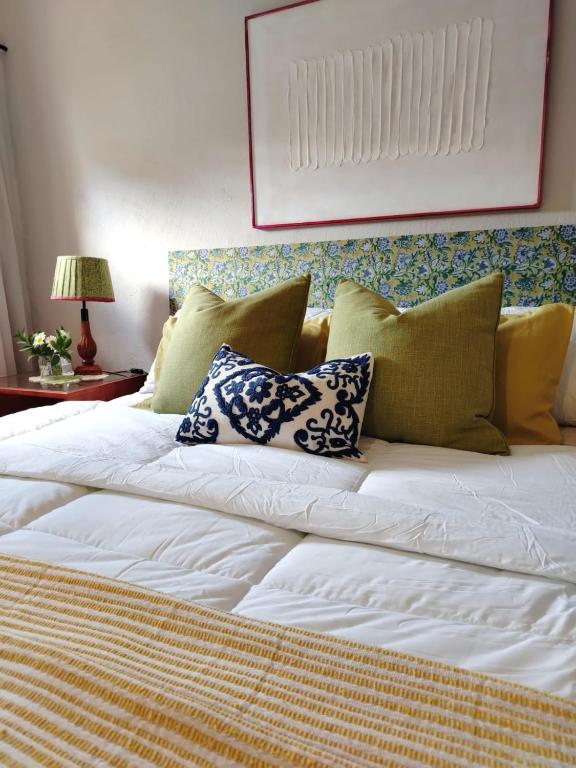 a large white bed with several pillows on it at Riverside Cottages in Graaff-Reinet