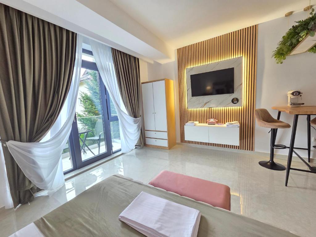 a living room with a couch and a tv on a wall at Chic 2 Chic Boutique in Bucharest