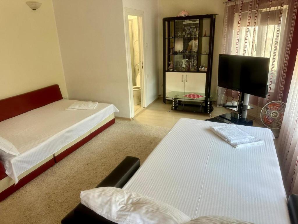 a small room with two beds and a television at Casa Vio parter in Eforie Nord