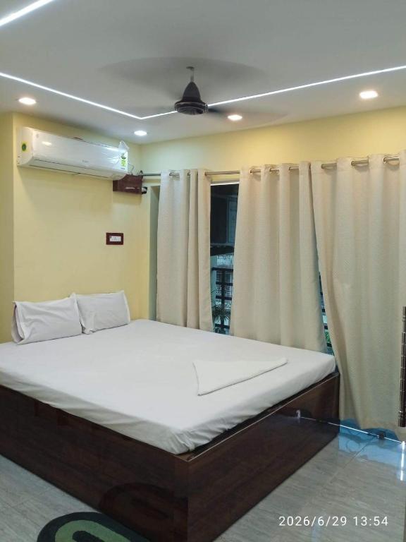 a large bed in a room with curtains at Royal Guest House in Baidyabāti