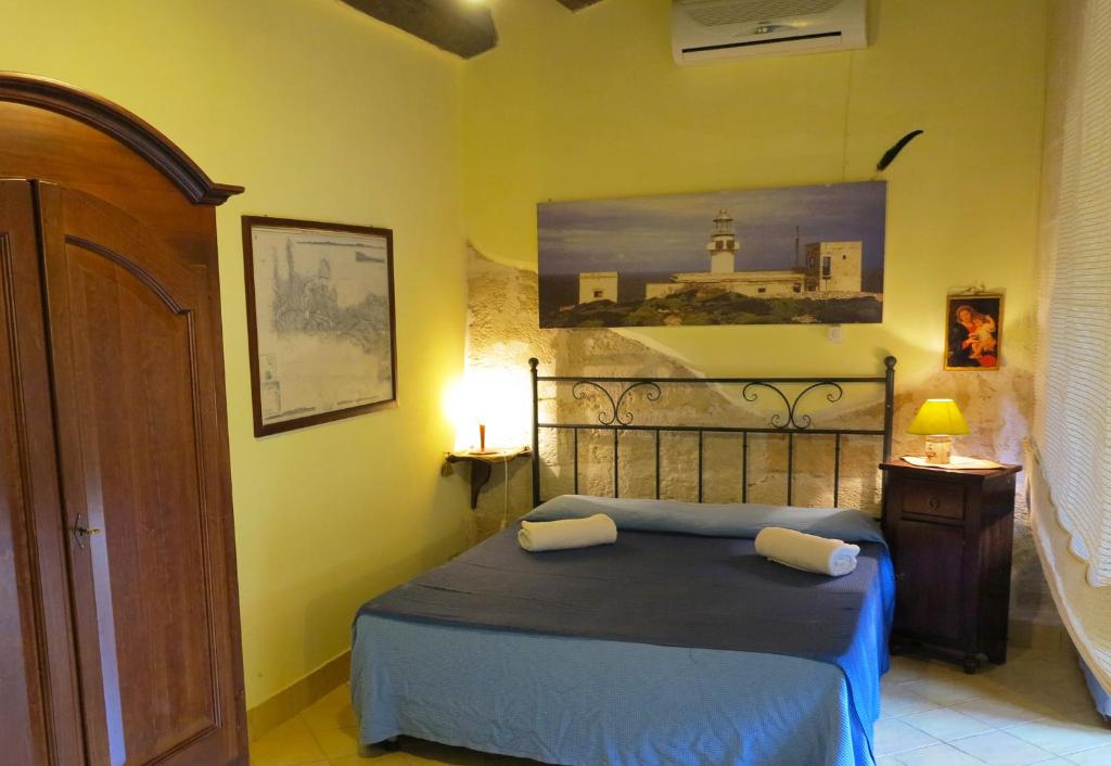 a bedroom with a bed with two pillows on it at Lisola Residence in Levanzo