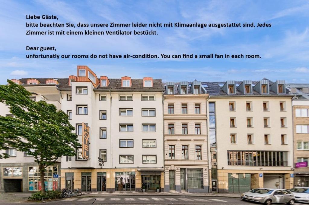 a large white building with cars parked in front of it at Hotel Flandrischer Hof in Cologne