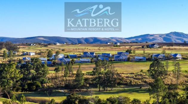 a group of houses in a field with mountains in the background at Katberg Hotel & Mountain Resort in Karberg