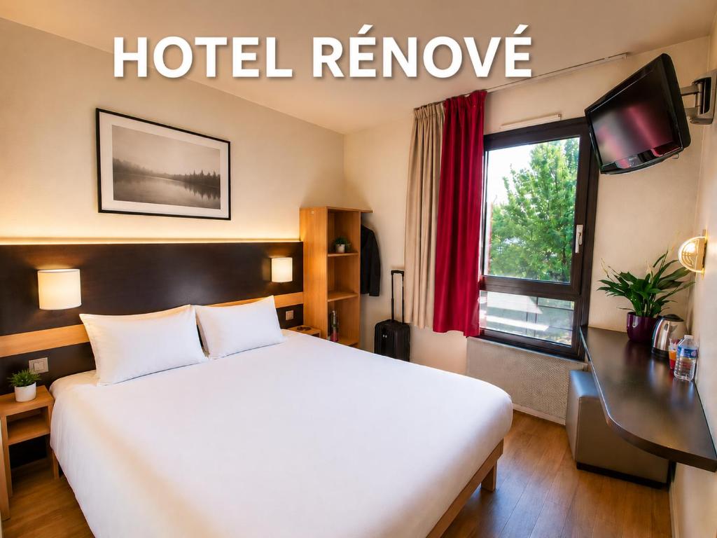 a hotel room with a white bed and a window at Hôtel Inn Design & Restaurant Chartres in Chartres