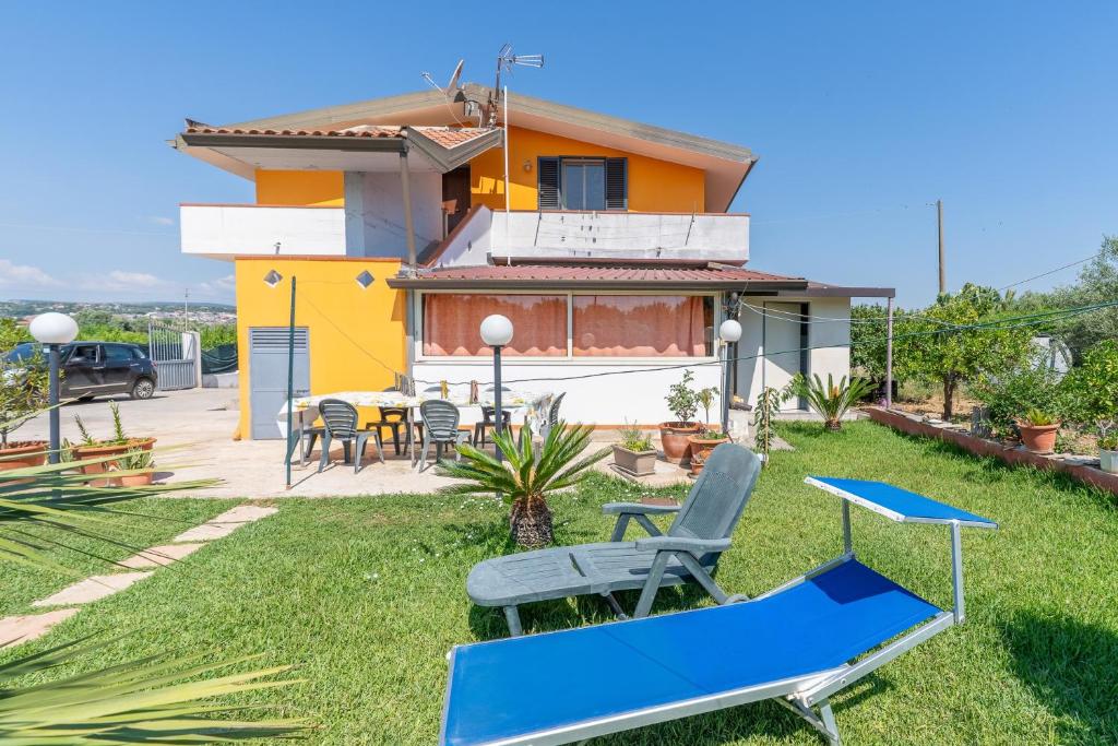 a house with a table and chairs in the yard at Villa Caterina in Solarino