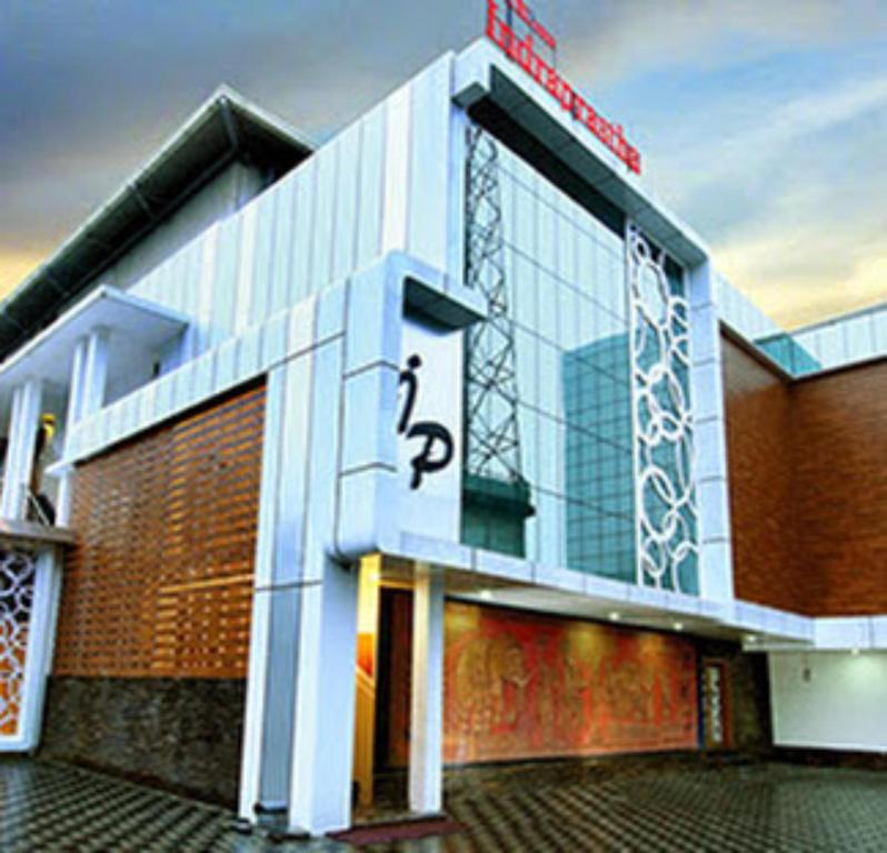 a building with a sign on the side of it at Hotel New Indraprastha in Adūr