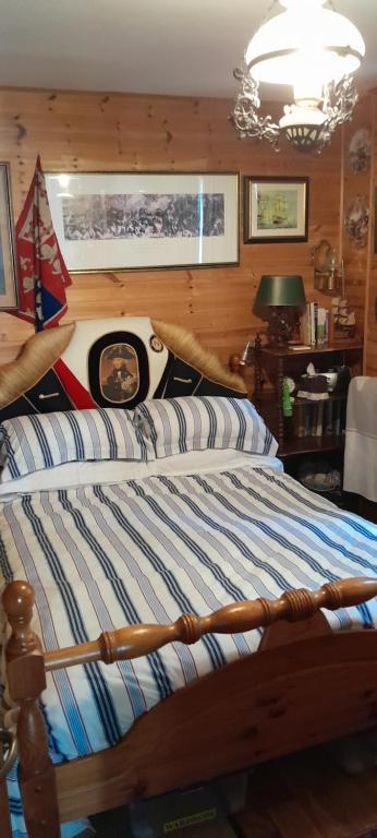 a bedroom with a bed with a striped comforter at NELSONS CABIN in North Creake