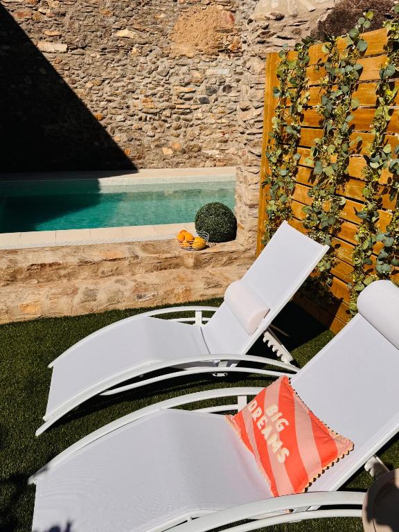a white chair sitting on the grass next to a pool at Hotel Carbonell in Llança