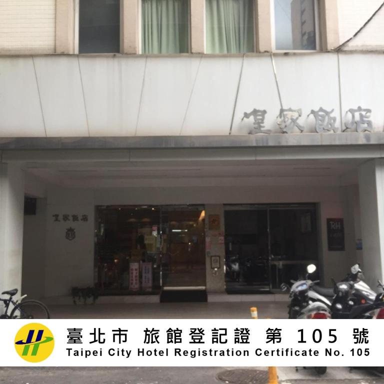 a building with a parking garage with motorcycles parked outside at Royal Hotel in Taipei