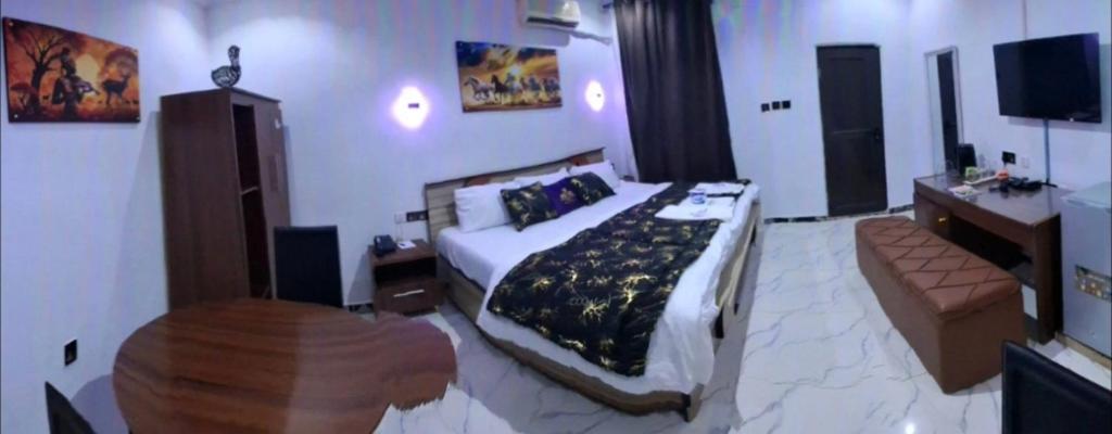 a bedroom with a large bed and a couch at Pandorax Hotel Oluku in Benin City