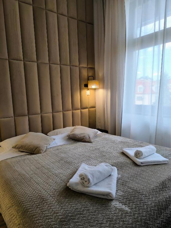 a bedroom with two towels on a bed at Place4You Studio w Sercu Ostródy in Ostróda