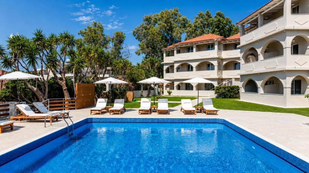a swimming pool in front of a building with a resort at Noma Vasilikos in Vasilikos