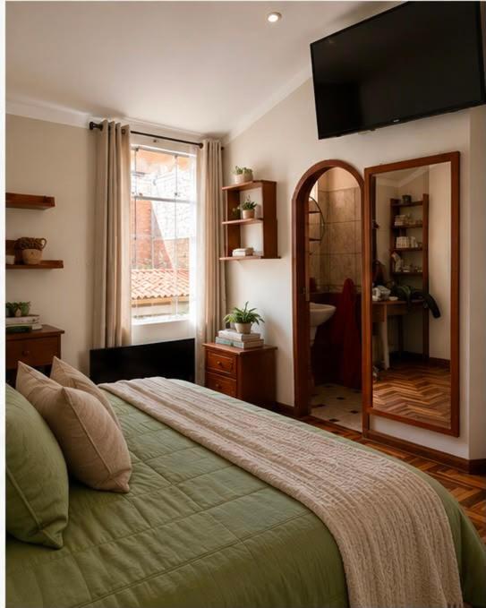a bedroom with a large bed and a mirror at Rolys House in Los Baños del Inca