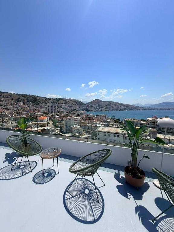 a balcony with chairs and a view of a city at Villa Saral Mar in Sarandë