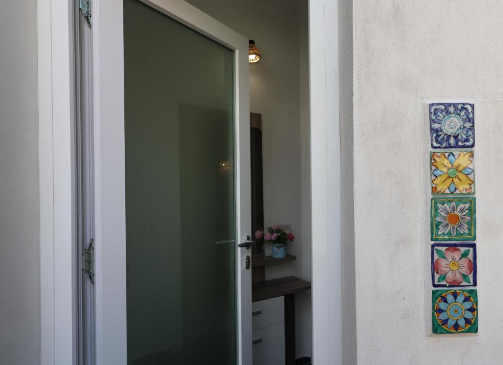 a glass door leading into a bathroom with stained glass windows at Maison Gadì in Maiori