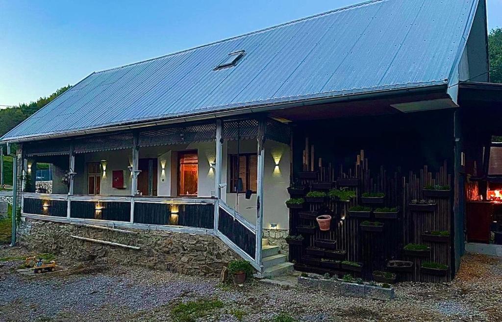 a house with a metal roof with plants on it at Chata LEA in Ratkovské Bystré