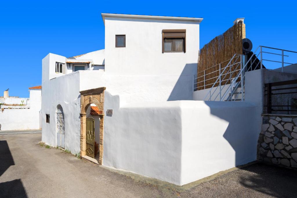 a white building with a door on the side at IOANNAS ARCH HOUSE a in Gennadi