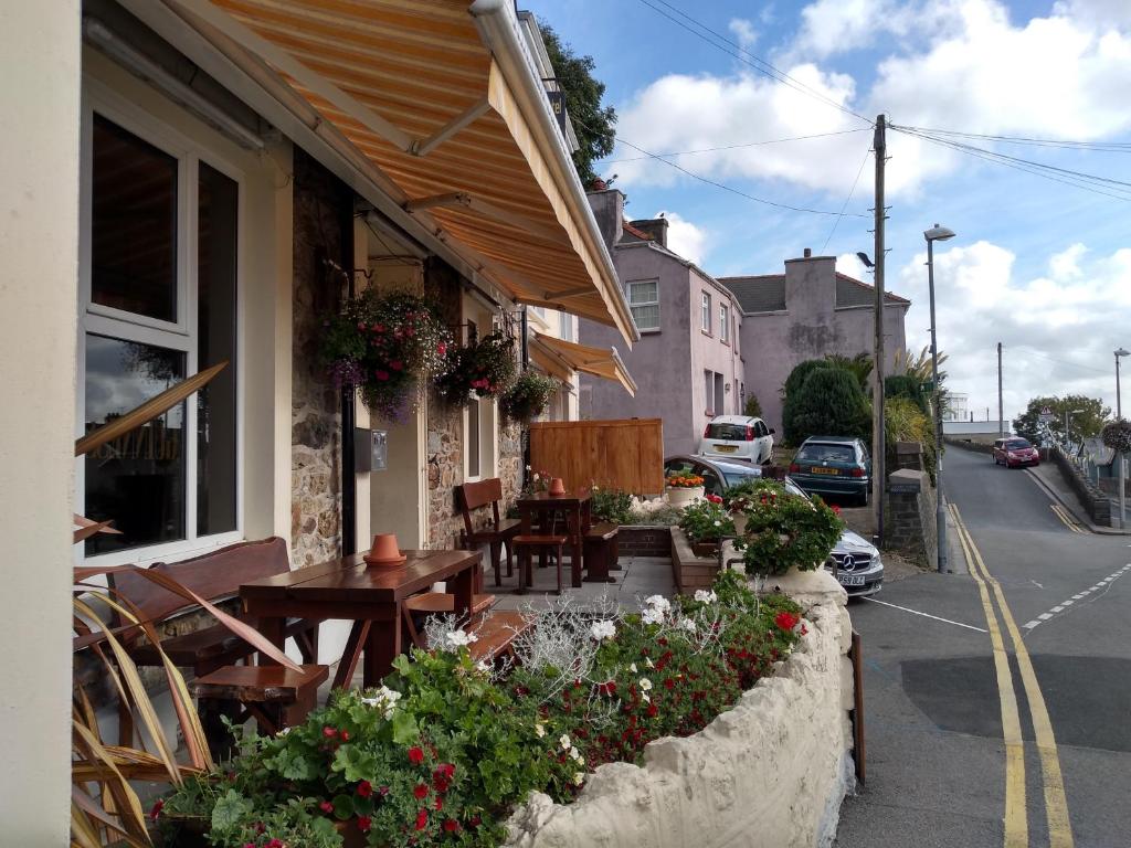 ein Restaurant mit Tischen und Stühlen am Straßenrand in der Unterkunft Glendower Hotel in Goodwick