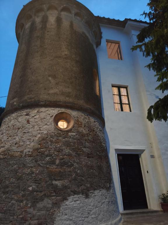 a building with a clock tower in front of it at Nostra Torre in Filettole