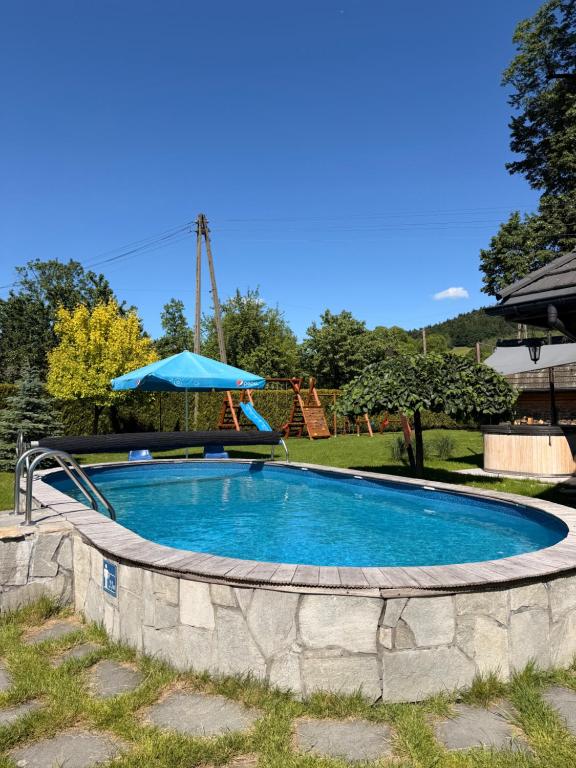 a swimming pool with a slide in a yard at Gniazdko Pod Lipą in Andrychów