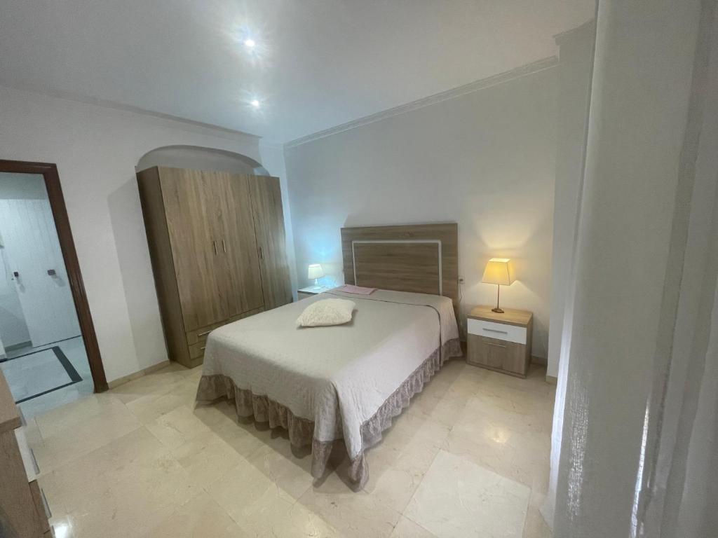 a bedroom with a bed and a mirror at Apartamento CASA EL MORABITO in Puente Genil