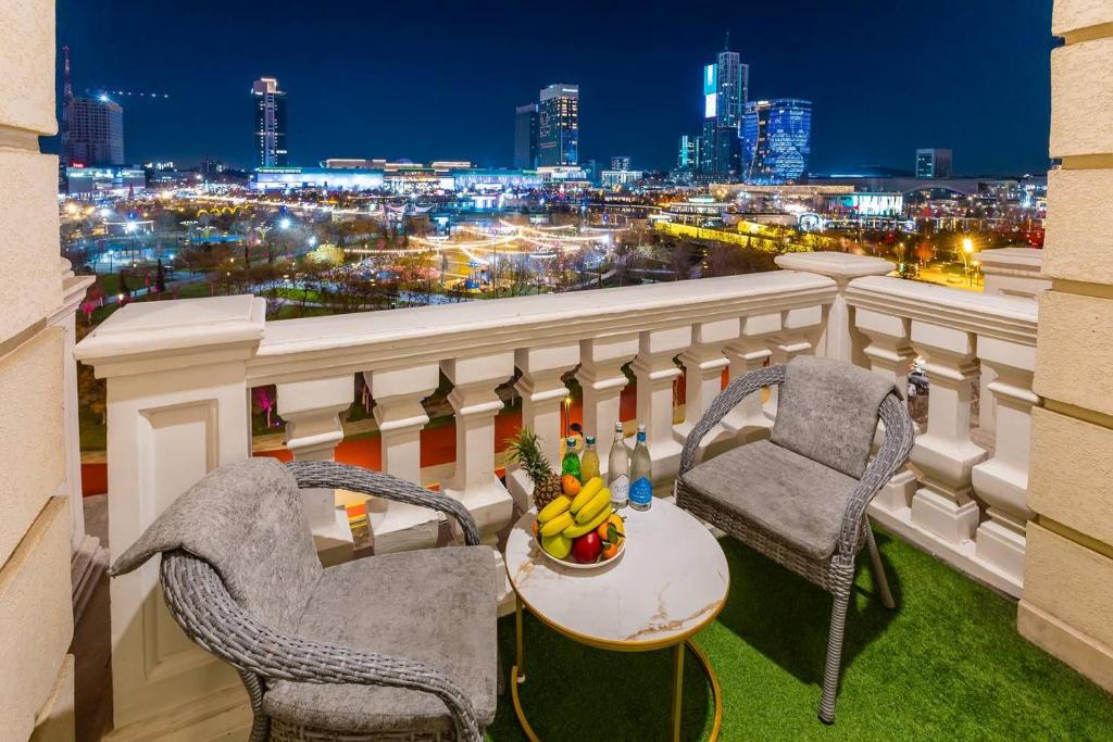 a balcony with two chairs and a table with fruit at Boulevard Residence Suite, 3 in Tashkent