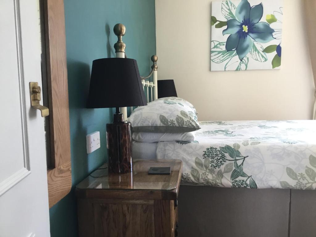a bedroom with a bed with a lamp on a night stand at Seaham in Weymouth