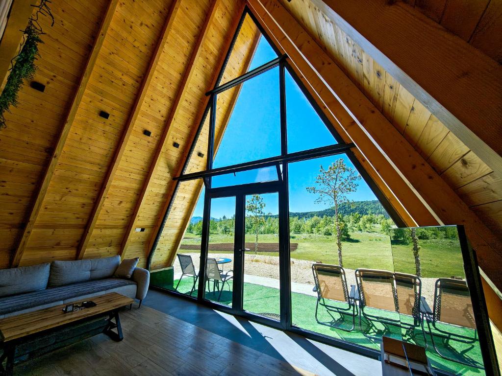 a living room with a couch and a large window at Wolf Ridge Mountain Cabin Montenegro in Plužine