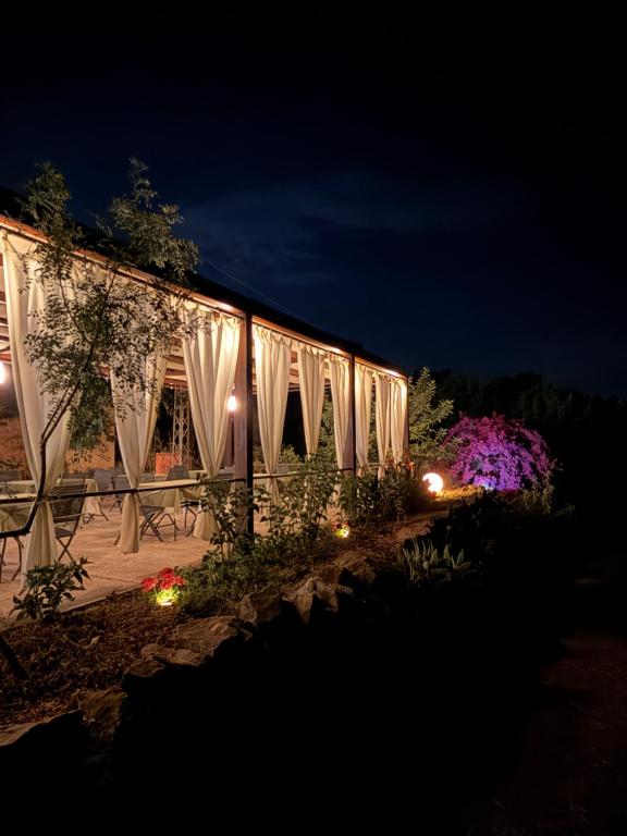a building with white curtains and lights at night at La Manna di Zabbra in Pollina
