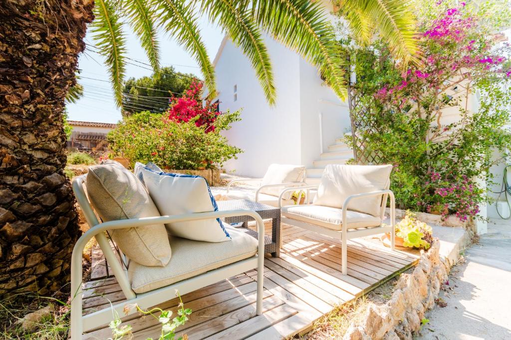 a patio with chairs and a palm tree at Holiday Home Kety in Portals Nous