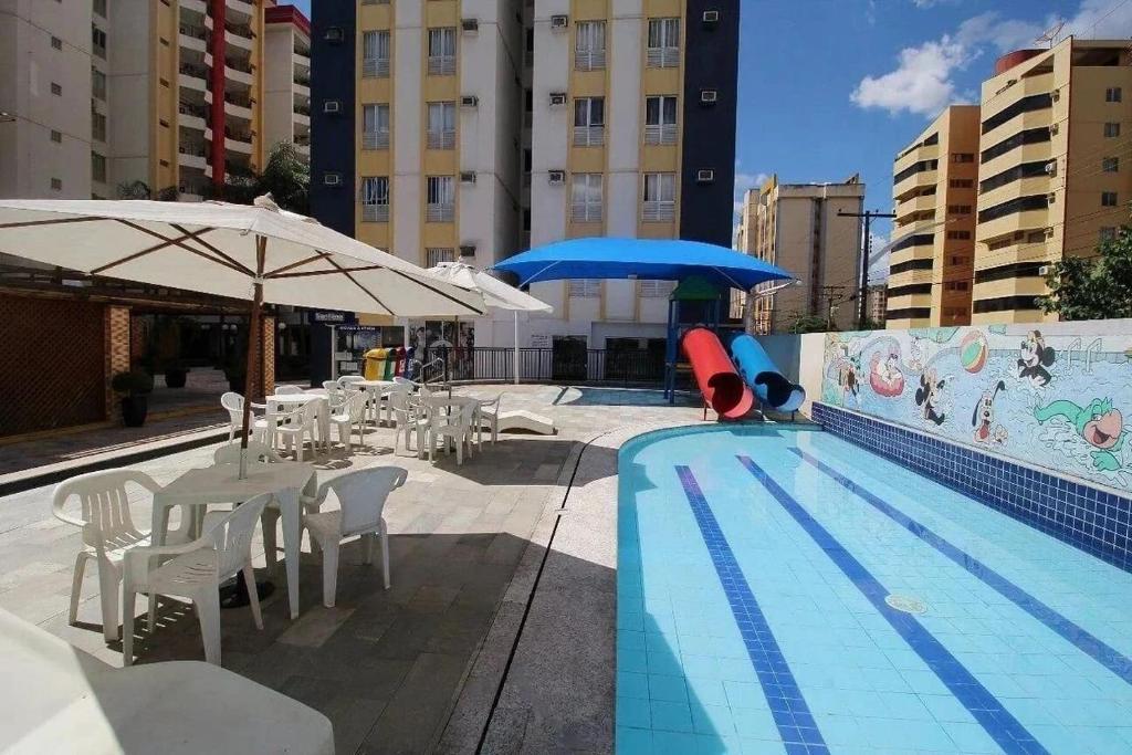 a swimming pool with tables and chairs and umbrellas at CRCN - Eldorado Thermas Park in Caldas Novas