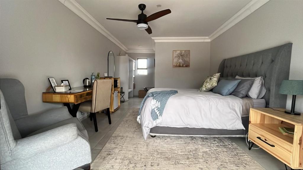 a bedroom with a bed and a desk and a chair at Sebeshong Guest House - Moletjie in Ga-Komape