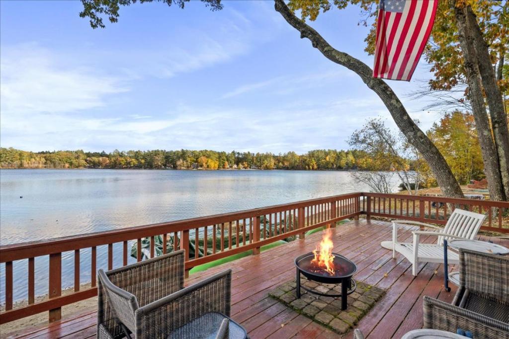 a fire pit on a deck with a view of the water at Waterfront w/ Prvt Dock & Firepit | Sleeps 8 in Acton