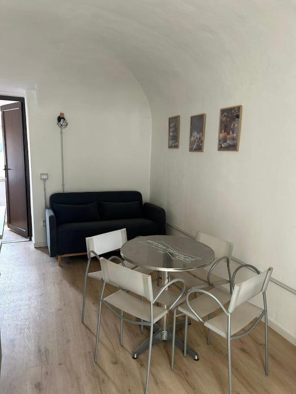 a living room with a table and chairs and a couch at Pola's House Biella Bio in Biella