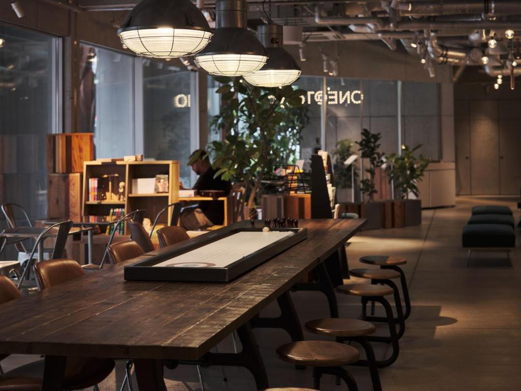 a table in a store with chairs and lights at ONE@Tokyo by insomnia in Tokyo