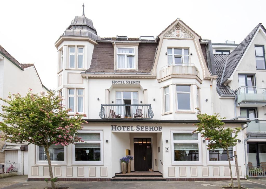 a large white building with a hotel schedule at Hotel Seehof Norderney OHG in Norderney