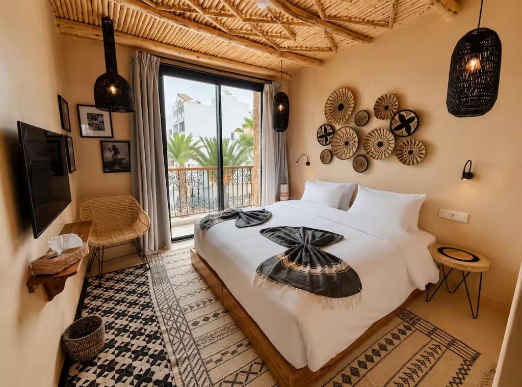 a bedroom with a large bed and a large window at Palm Surf & Spa Hotel in Agadir