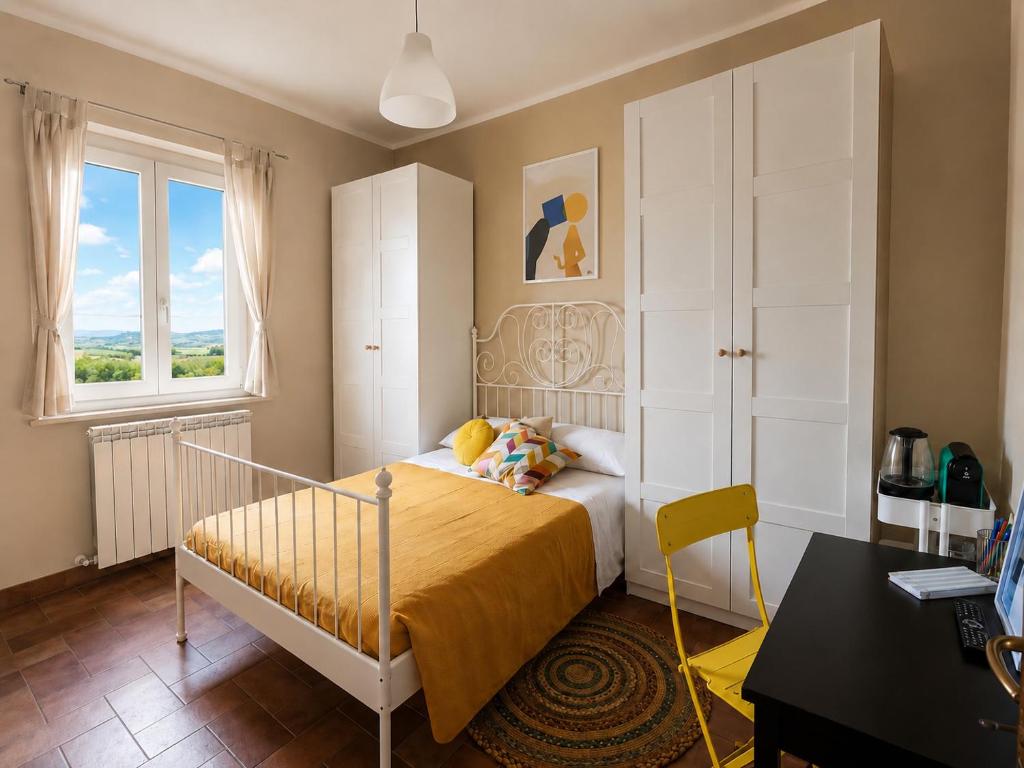 a bedroom with a bed and a desk and a window at Capozucca Home in Città della Pieve