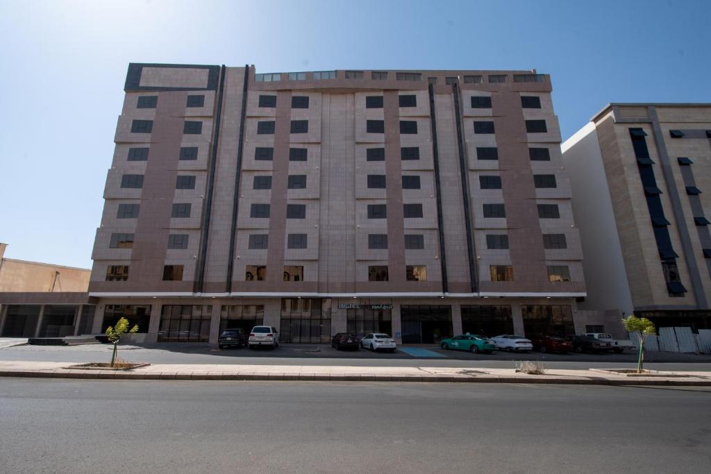 a large building with cars parked in a parking lot at Continent Al Marzam in Medina