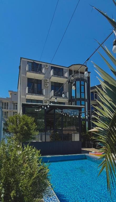 ein Gebäude mit einem Schwimmbad vor einem Gebäude in der Unterkunft Minervaside in Gonio