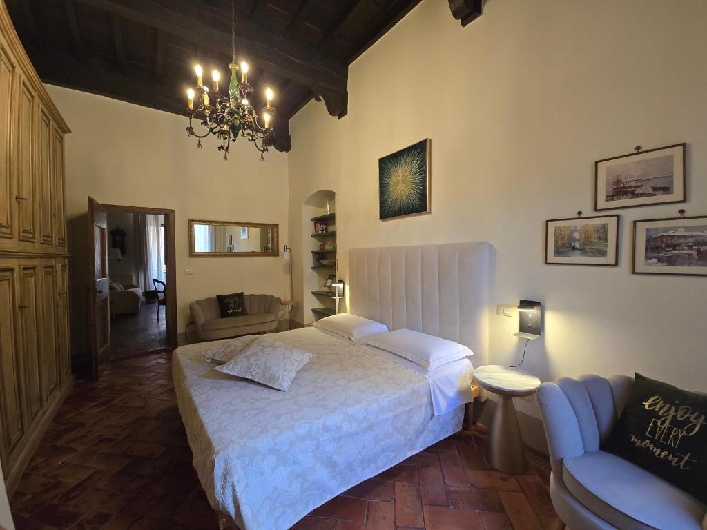 a bedroom with a bed and a couch and a chandelier at Finestra Dell'Angelo in Pienza