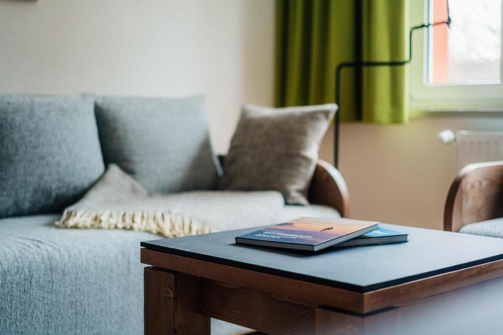 a coffee table with a book on it next to a couch at Bodeapartment 3 in Elend
