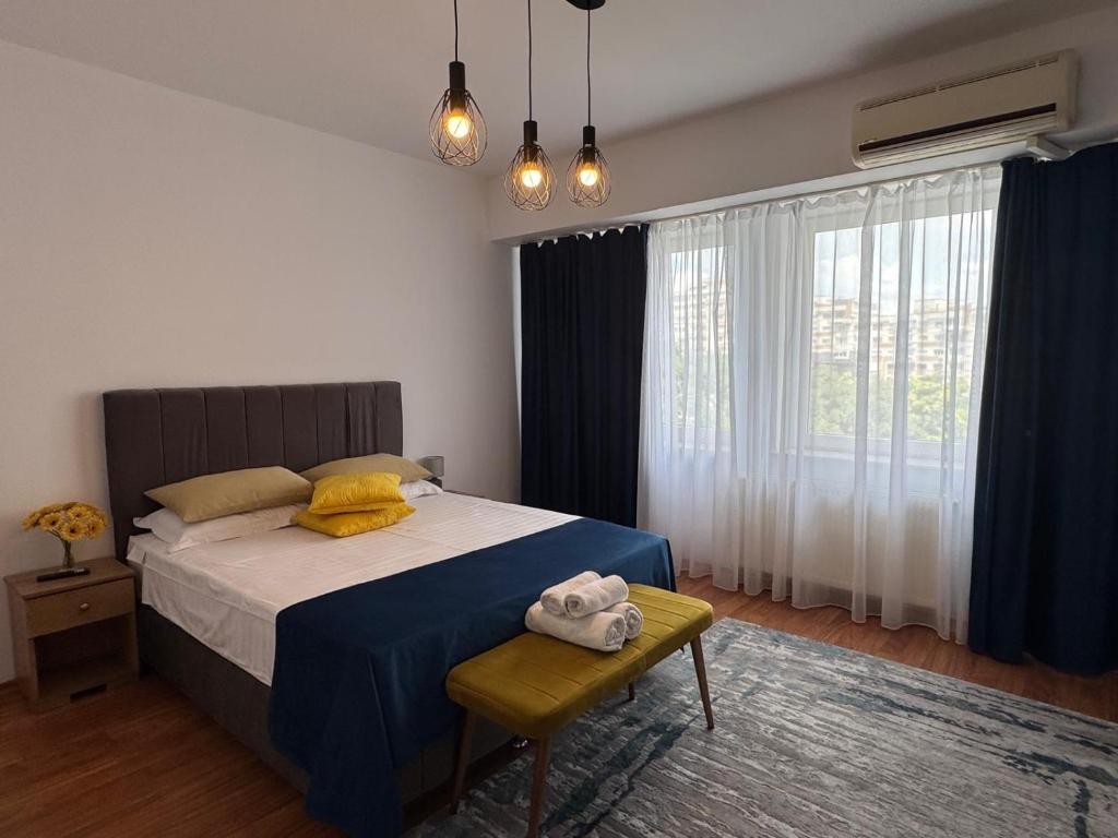 a bedroom with a bed with a blue and yellow blanket at Dream City Center in Piteşti