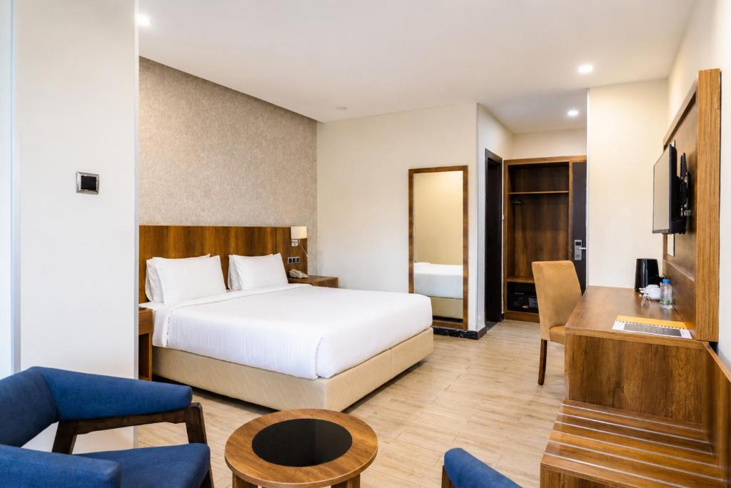 a bedroom with a bed and a living room at Jalo Hotel - Shashemene in Shashemenē