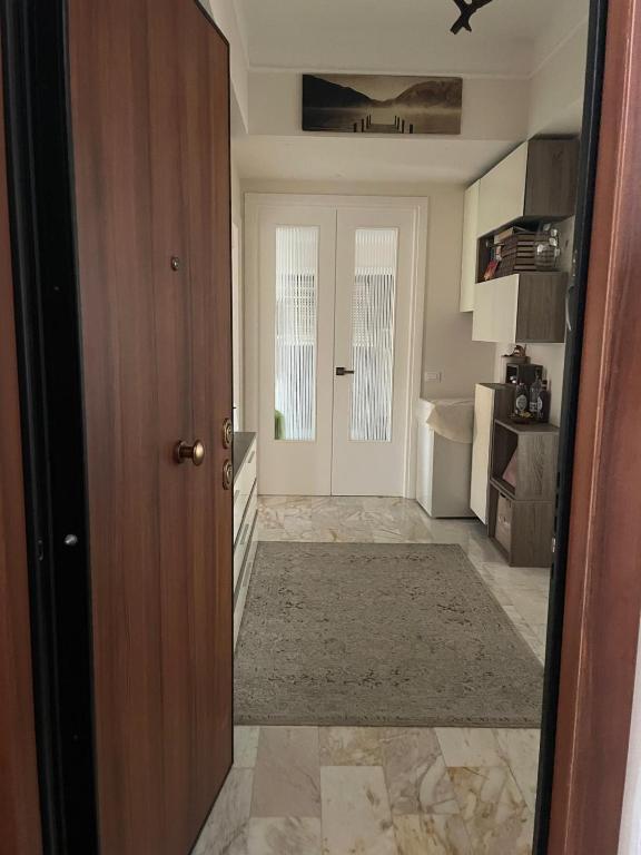 a room with a door and a hallway with a rug at A casa mia in Gaeta