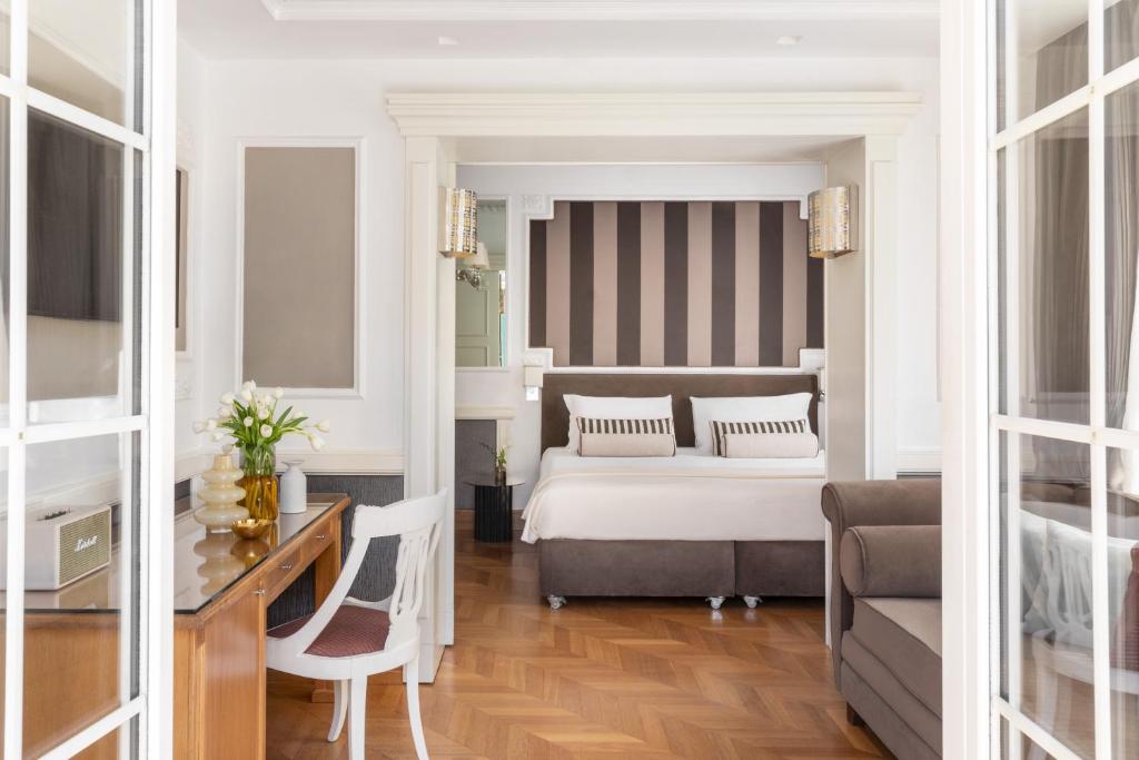 a bedroom with a bed and a desk and a couch at The Britannia Hotel in Rome
