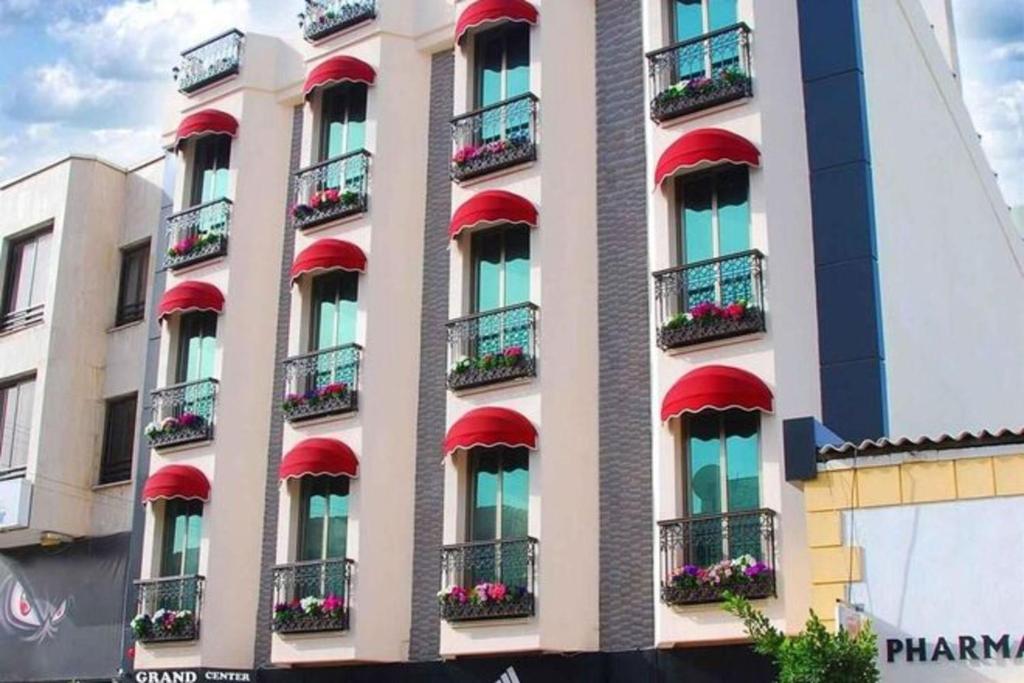 a building with red balconies and windows with flowers at Grand Center Boutique Hotel in Kyrenia