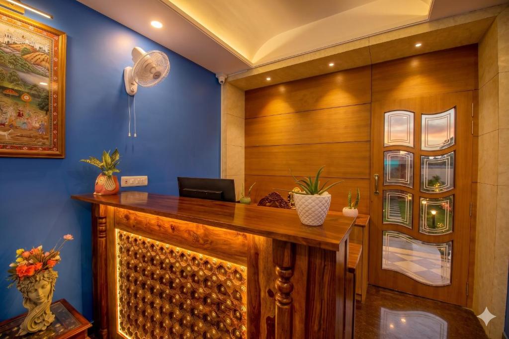 an office with a wooden desk with a laptop on it at Hotel Gems Suites in Jaipur