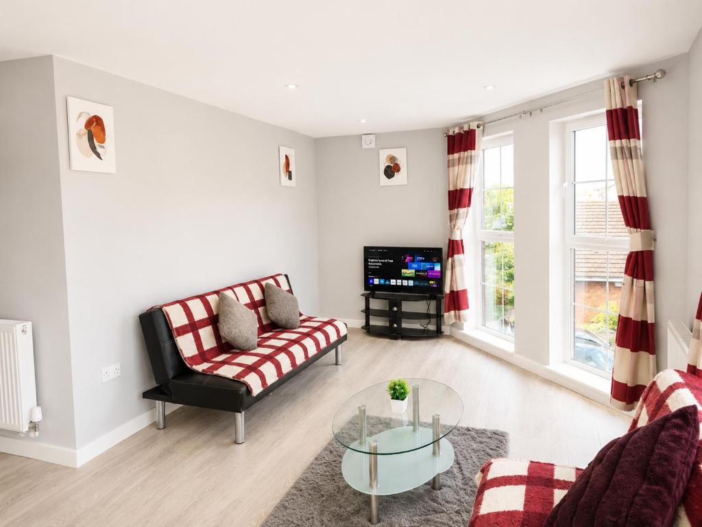 a living room with a couch and a glass table at Dainty Curve in Kettering